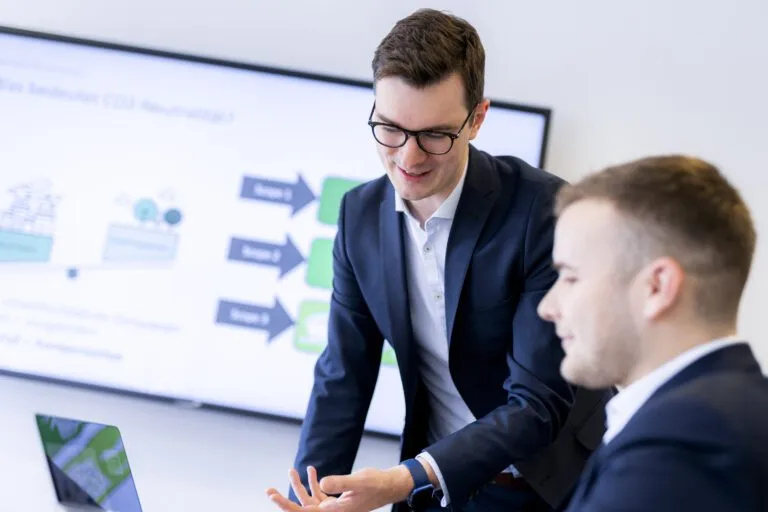 Ausschnitt eines CRM-Potenzial-Workshops | zwei Menschen sprechen in einem B&uuml;ro miteinander